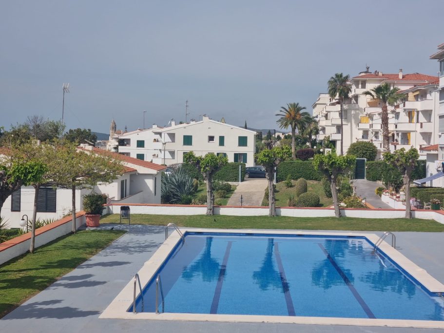 Piscina al aire libre rodeada de palmeras y edificios residenciales.