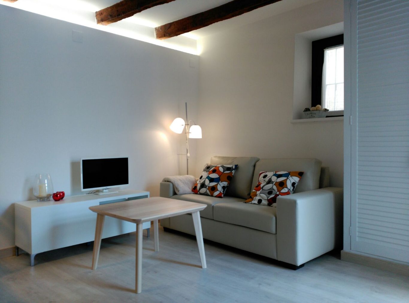 Sala de estar moderna con sofá, mesa de madera y decoración minimalista.